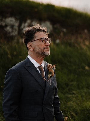 John P. Clark, recipient of the 2026 ASME IGTI Aircraft Engine Technology Award, standing outdoors in a dark suit with a boutonniere, looking into the distance.